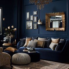 a living room with dark blue walls and lots of pillows on the couches,