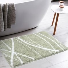 a bath tub sitting next to a rug on the floor