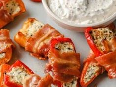 bacon wrapped peppers with ranch dip on the side, ready to be cut into bite - sized pieces