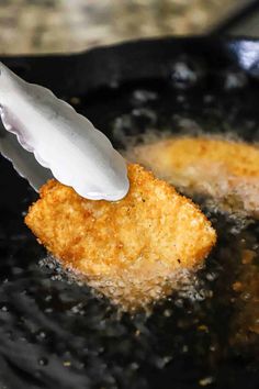 fried food being cooked in a frying pan with a spatula sticking out of it