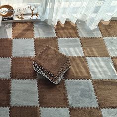 a brown and white checkered rug on the floor next to a window with curtains