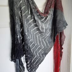 a black and red shawl hanging on a wall next to a white door,