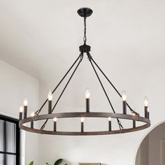 a chandelier hanging from the ceiling in a dining room with potted plants