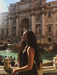 a woman standing in front of a fountain