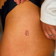 a woman's stomach with a small tattoo on the lower part of her belly