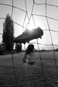 a soccer goalie's feet hanging from the net