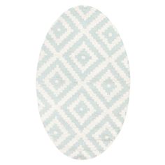 an oval shaped rug with white and blue geometric designs on the outside, in front of a