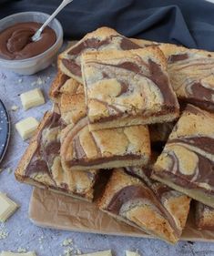 a table topped with lots of different types of desserts next to a bowl of chocolate