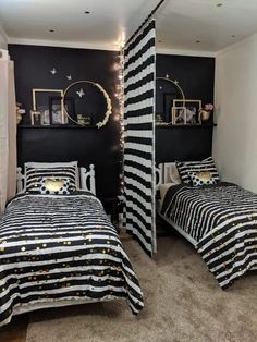 two beds in a room with black walls and gold stars on the beddings