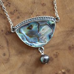 Our new Rainbow Abalone Y Pendant in stunning quality Abalone Shell is dramatic and so versatile. It will match absolutely everything! Abalone - aka Paua Shell - is simply adorned with our own extruded, .925 Sterling Silver textured wire, and accented by a free-wired freshwater peacock pearl 7/8mm below. Includes our perfect .925 Sterling Silver Chain - 16-18 inches.  Rainbow Abalone - 30X20mm Pendant top to bottom 1 1/4 inch (includes pearl) Side to side 1 1/4 inch All metal .925 Sterling Silve Sterling Silver Pendant Necklace With High Luster, High Luster Sterling Silver Pendant Necklace, Paua Shell Jewelry, Abalone Necklace, Peacock Pearl, Rainbow Pearl, Paua Shell, Boho Pendant, Shell Jewelry