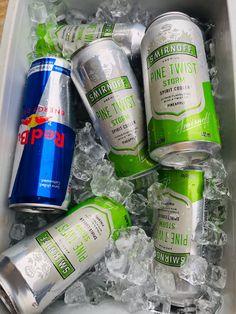 several cans and cans of soda sitting in an ice container filled with ice cubes