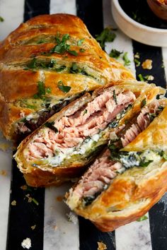 a sandwich cut in half sitting on top of a black and white striped table cloth