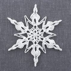 a white crocheted snowflake on a gray surface