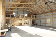 the inside of a large building with lots of windows and wood beams on the ceiling