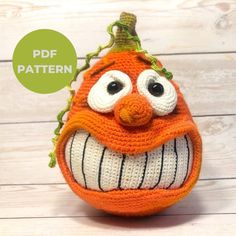 an orange crocheted stuffed animal with big eyes and a smile on it's face