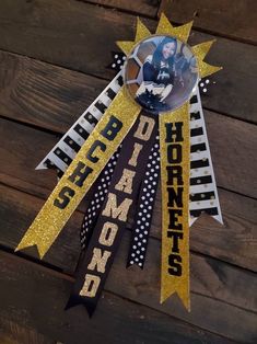 a black and gold ribbon with the word diamond on it is hanging from a wooden wall