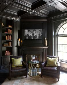 two chairs and a table in front of a fireplace