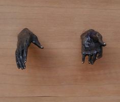 two fake hands with black paint on them