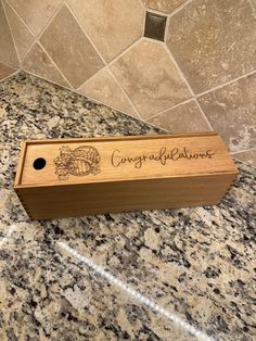 a wooden box sitting on top of a marble counter