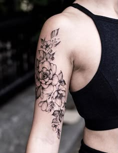 a woman with a flower tattoo on her left arm and right arm behind her back