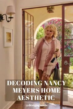 an older woman walking into a home with the words decoding nancy meyers home aesthetic