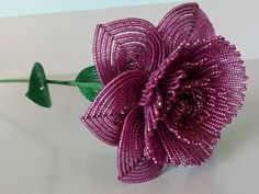 a purple flower sitting on top of a white table