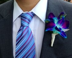 a man wearing a suit and tie with a boutonniere on his lapel