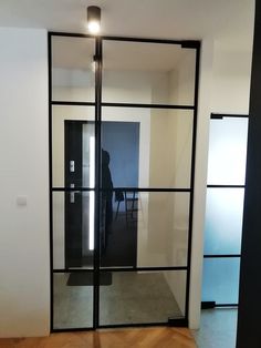 an empty room with glass doors and a person sitting at a desk in the background