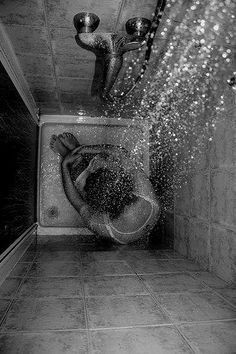 black and white photograph of a person in a bathroom with water coming out of the toilet