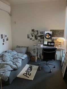 a bedroom with a bed, desk and computer on the floor next to a window