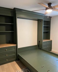 an empty room with green cabinets and a white board on the wall next to it