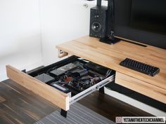 an open drawer underneath a computer desk with a keyboard and mouse on it in front of a monitor