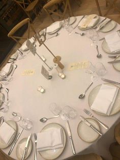 a white table topped with lots of silverware and place settings on top of it