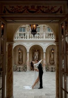 a bride and groom kissing in an archway