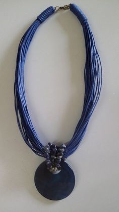 a blue necklace with silver beads on it