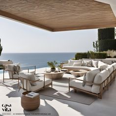 an outdoor living area overlooking the ocean with white furniture and greenery on either side