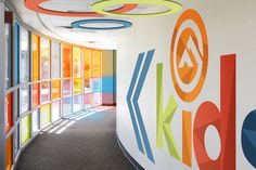 an office hallway with brightly colored circles painted on the wall and windows in the background