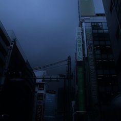 a city street at night with tall buildings