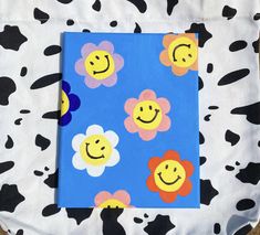 a cow print bag with a smiley face drawn on it's front and sides