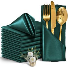 a stack of green napkins with gold forks and spoons next to each other