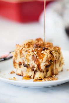 a piece of dessert is being drizzled with caramel syrup on a white plate