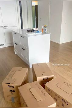 several boxes are stacked on the floor in front of a kitchen island and countertop