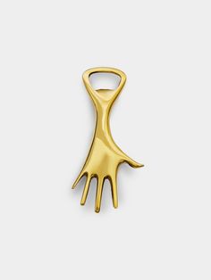 a gold brooch that is shaped like a hand with two fingers on it, against a white background