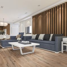 a modern living room with wood paneling and blue couches, white coffee table