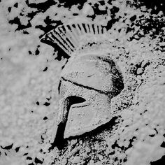 an ancient roman helmet in the sand