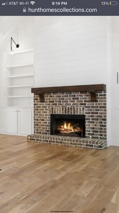 an empty living room with a fireplace and white walls