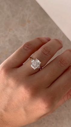 a woman's hand with a diamond ring on it