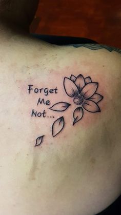 a woman's back with a tattoo saying forget me not