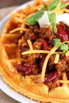 a waffle topped with chili and sour cream