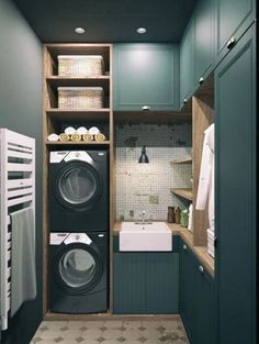 a washer and dryer in a small room with blue walls, cabinets and flooring